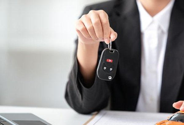 продавец автомобиля делает пометки в блокноте во время звонка